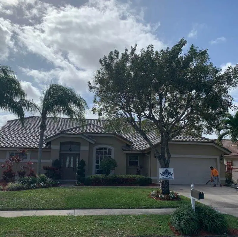 Finished concrete tile roof with the Mendieta Roofing yard sign on the lawn